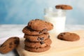 Wooden board with stack of tasty chocolate chip cookies Royalty Free Stock Photo