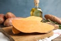 Board with sweet potato on kitchen table Royalty Free Stock Photo