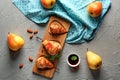 Wooden board with tasty baked pears and syrup on grey table Royalty Free Stock Photo