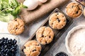 Wooden board with tasty blueberry muffins and fresh berries on table Royalty Free Stock Photo