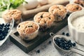 Wooden board with tasty blueberry muffins and fresh berries on table Royalty Free Stock Photo