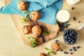 Wooden board with tasty blueberry muffins on light table Royalty Free Stock Photo