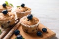 Wooden board with tasty blueberry muffins on table Royalty Free Stock Photo