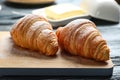 Wooden board with tasty on table, closeup. French pastry