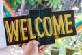 Wooden board with text welcome in man hand. Bali island. Welcome sign. Royalty Free Stock Photo