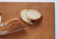 On a wooden Board there is a baguette and cut pieces of white bread baguette Royalty Free Stock Photo