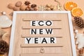 On a wooden board there is an inscription eco-new year. Natural decorations for New Year and Christmas. Ecodesign.