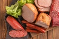 Wooden board with variety of delicious deli meats on table Royalty Free Stock Photo