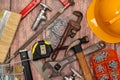 On a wooden board, a variety of tools needed for home repair are irregularly placed