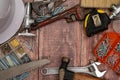 On a wooden board, a variety of tools needed for home repair are irregularly placed