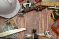 On a wooden board, a variety of tools needed for home repair are irregularly placed