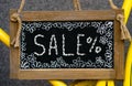 wooden board with word sale written with chalk, signboard. symbol of information, business, marketing and selling