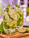 On wooden boards are glasses with mohito and napkin.