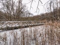 Wooden boardwalk on a frozen pond
