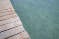 A wooden boardwalk planks of wood from a pier going over the ocean or swimming pool Royalty Free Stock Photo