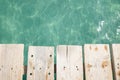 A wooden boardwalk planks of wood from a pier going over the ocean or swimming pool Royalty Free Stock Photo