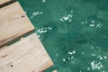 A wooden boardwalk planks of wood from a pier going over the ocean or swimming pool Royalty Free Stock Photo