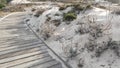 Wooden boardwalk trail, sand dune, California coast. Footpath walkway or footway