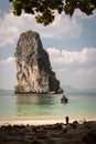 Wooden boat arriving on beach with rocky cliff Royalty Free Stock Photo