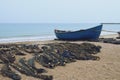 Wooden Boat Bordered On The Beach Next To Fishing Nets.
