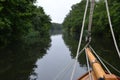 Wooden boat bow, bowsprit and rigging only quietly on a tranquil, tree lined river Royalty Free Stock Photo