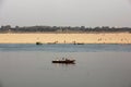 A wooden boat with a crowd of Hindu pilgrims in the waters of the river Ganga in the