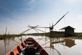 Wooden boat cruising along the lake passing the fisherman's house Royalty Free Stock Photo