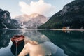 Wooden boat on the crystal lake with majestic mountain behind. Reflection in the water. Chapel is on the right coast Royalty Free Stock Photo