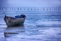 Wooden boat left on the low tide beach Royalty Free Stock Photo
