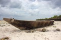 Wooden boat on low tide. Zanzibar beach with old nautical vessel. African seascape with cloudy sky. Empty coast of Indian Ocean. Royalty Free Stock Photo