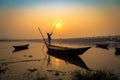 Wooden boat with oarsman at sunset on river Damodar. Royalty Free Stock Photo