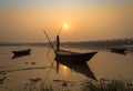 Wooden boat with oarsman at sunset on river Damodar, near Durgapur Barrage. Royalty Free Stock Photo