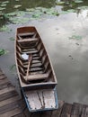Wooden boat with paddle, parked on the waterfront in the lotus pond