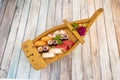 Wooden boat with passengers of Japanese sushi assorted from mantiquilla fish nigiri, red tuna, Norwegian salmon, makis with rice Royalty Free Stock Photo