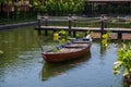 Wooden boat on the pond near the pier in a tropical garden in Danang, Vietnam Royalty Free Stock Photo