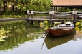 Wooden boat on the pond near the pier in a tropical garden in Danang, Vietnam Royalty Free Stock Photo