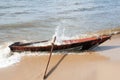 Wooden boat on the shore of lake Baikal and water splashes.