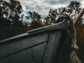 Wooden boat tied to a tree with a rope alongside grassy path in a forest, Hamilton, Ontario, Canada Royalty Free Stock Photo