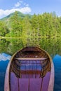 Wooden boat on the water and reflection of the mountains and wood in the lake Royalty Free Stock Photo