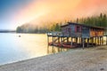 Wooden boathouse with boats on the alpine lake, Dolomites, Italy