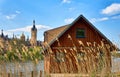 Wooden boathouse with a thatched roof on Lake Schwerin with castle in the background