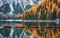 Wooden boats in Braies lake at sunrise in autumn in Dolomites