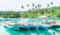 Wooden boats docked at the port. beautiful view of beach with clear blue water and coconut tree, Labuhan Cermin, Berau, Indonesia