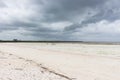 Wooden boats on low tide with dramatic cloudscape. Zanzibar beach with old nautical vessel. Rain season in tropics. Royalty Free Stock Photo