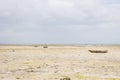 Wooden boats on low tide, toned. Zanzibar beach with old nautical vessel. African seascape with cloudy sky. Empty coast of ocean. Royalty Free Stock Photo