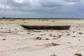 Wooden boats on low tide, toned. Zanzibar beach with old nautical vessel. African seascape with cloudy sky. Empty coast of ocean. Royalty Free Stock Photo