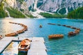 Wooden boats on the popular tourist lake Braies with amazing view of Dolomites Alps.
