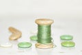 Wooden bobbin with green threads and buttons Royalty Free Stock Photo