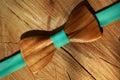 Wooden bow tie with ribbon mint colour lay on dry wood background. Diagonal line, flat lay. Natural and eco fashion