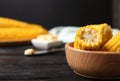 Wooden bowl of boiled corn cobs on black table. Space for text Royalty Free Stock Photo